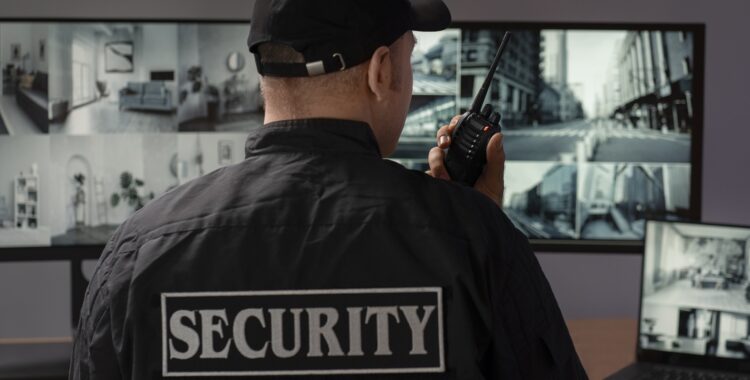 portrait-male-security-guard-with-radio-station-camera-screens