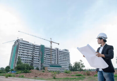 Young asian engineer looking paper plan of the building