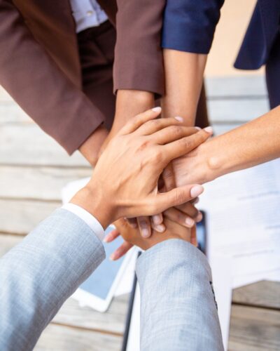 Successful business team expressing unity and putting their hands together. Closeup of people stacking hands. Team success or support concept